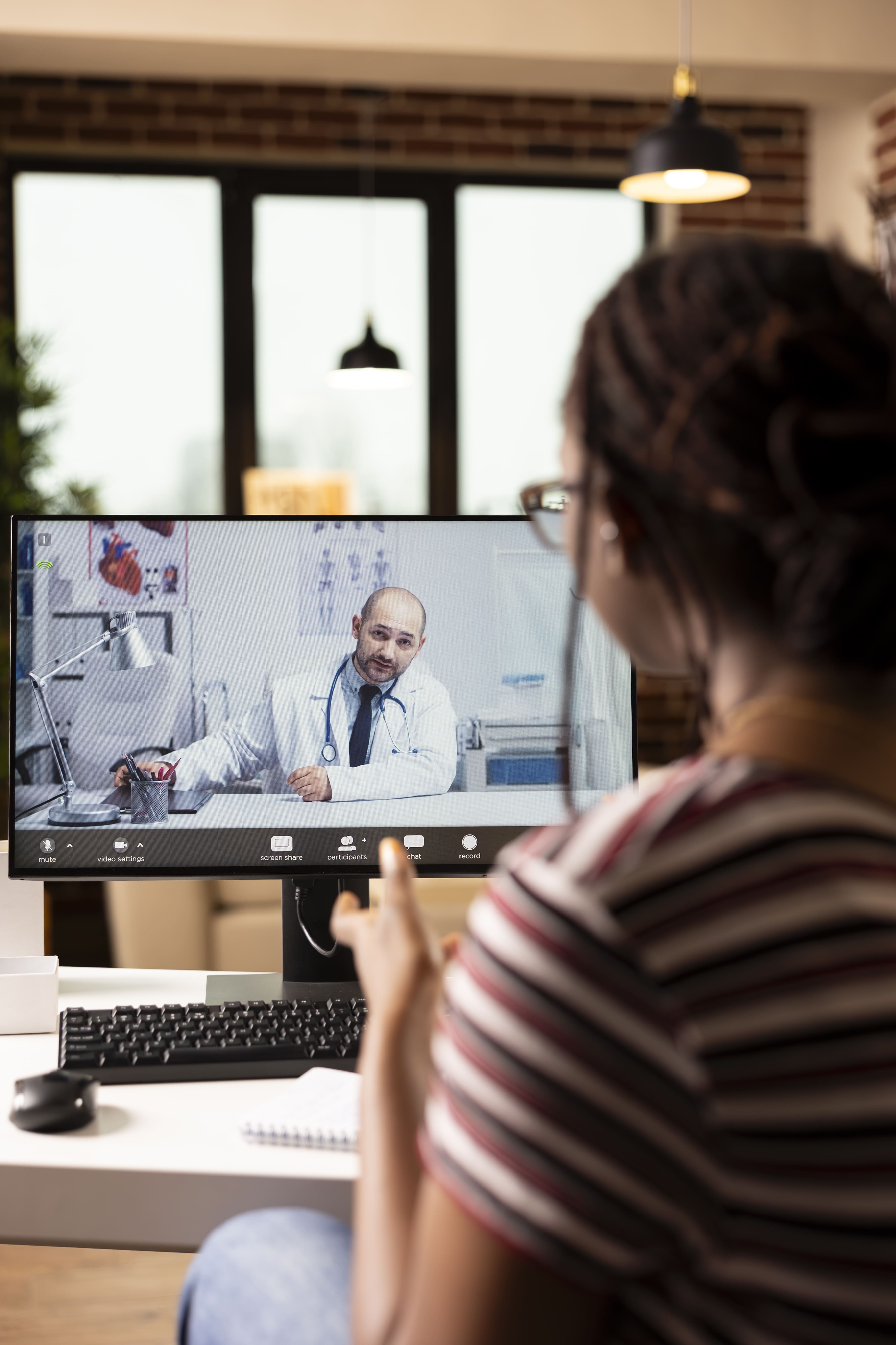 Mulher em consulta médica virtual pelo computador